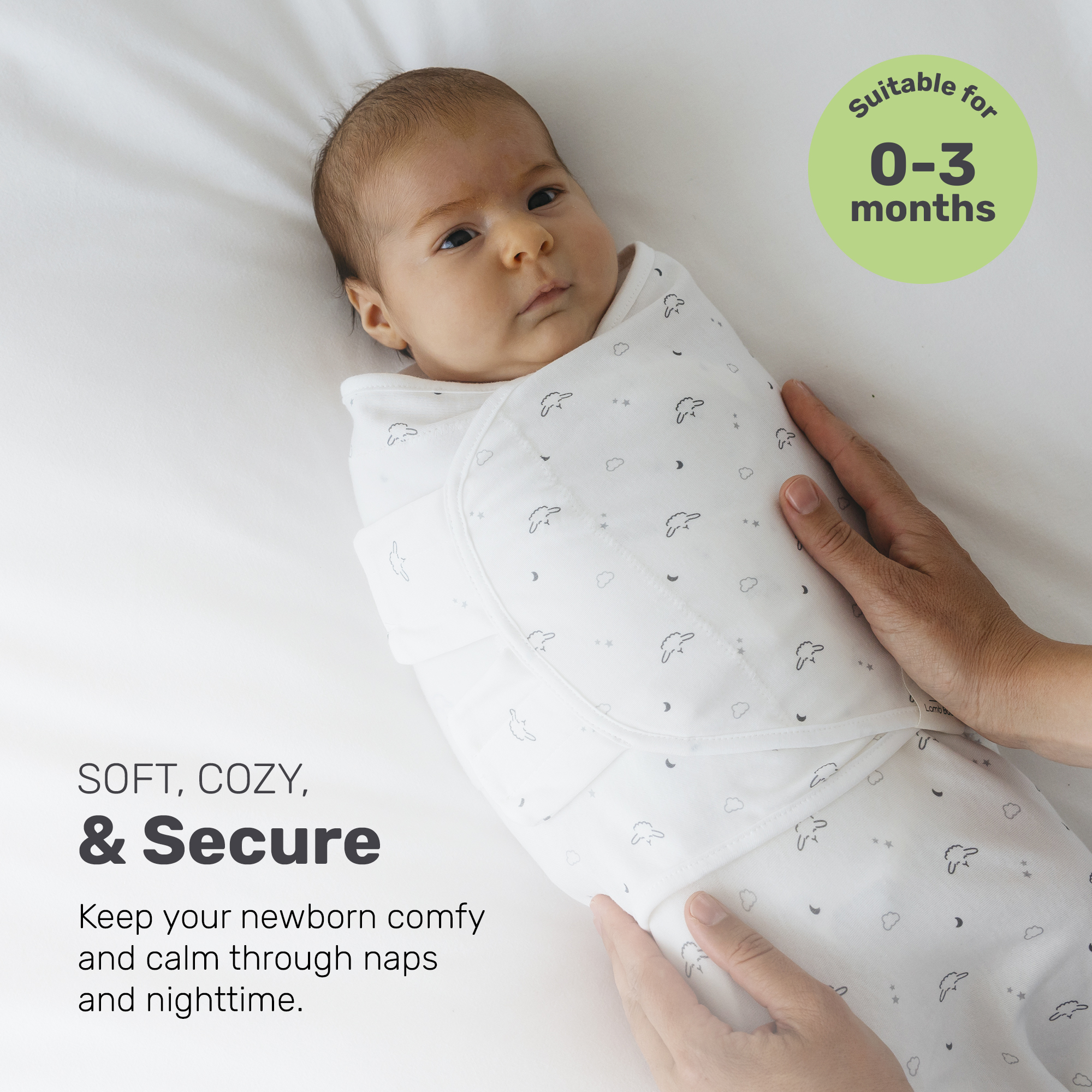 Newborn swaddled in a white Lamb Babies wrap with gray sheep prints, resting on a white sheet